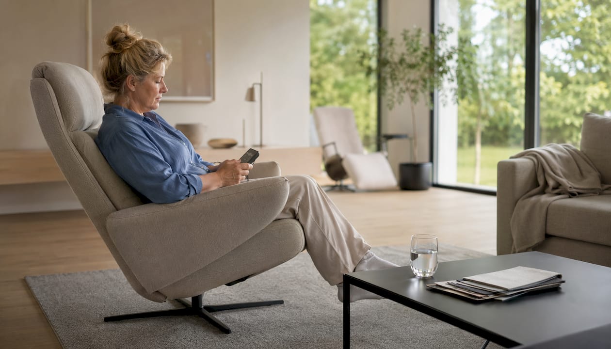 Vrouw probeert relaxstoel uit in de showroom