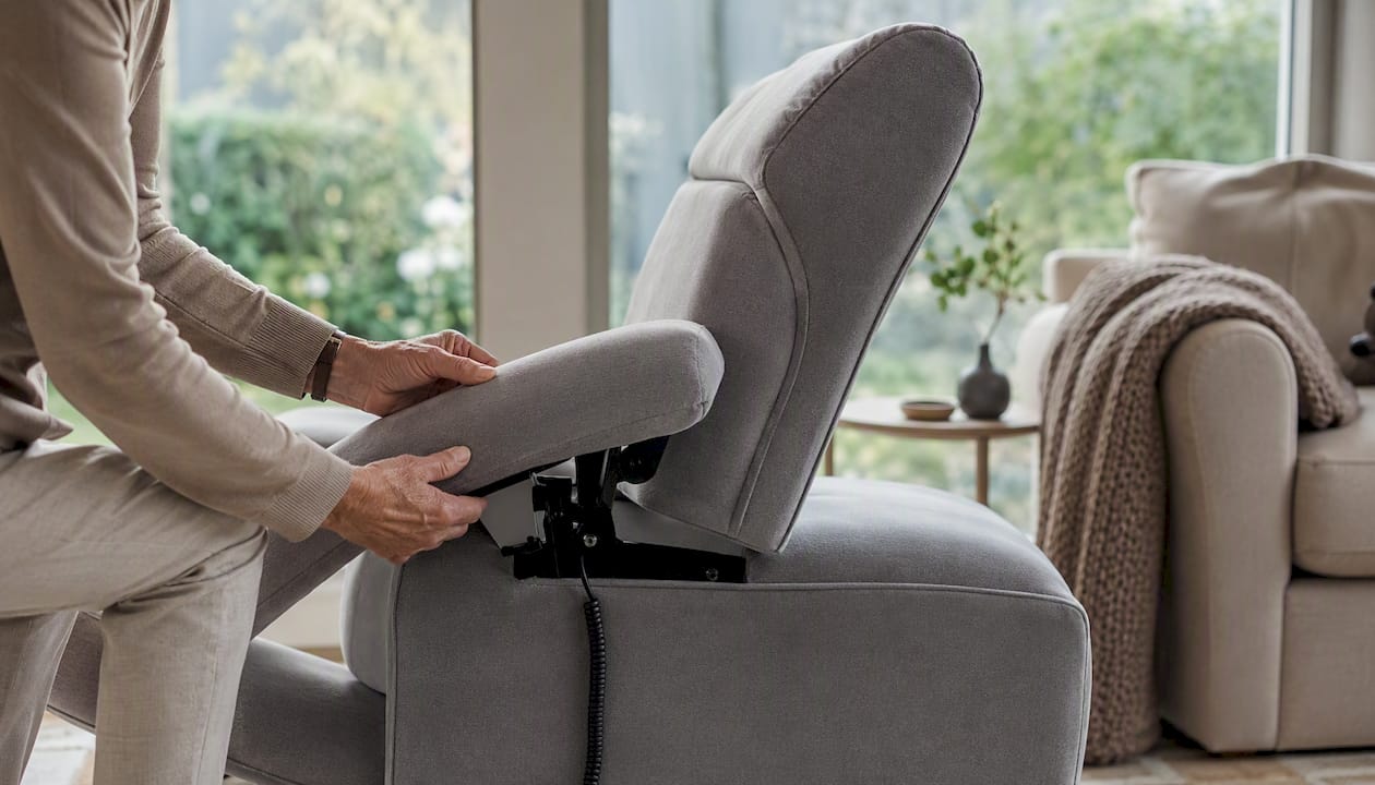 Een paar handen stelt de hendel van de relaxstoel bij