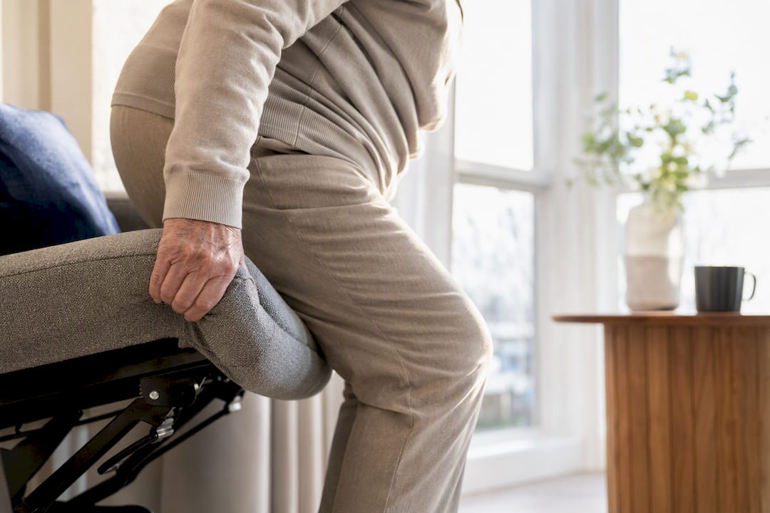 Persoon gebruikt de liftfunctie van een sta-op stoel