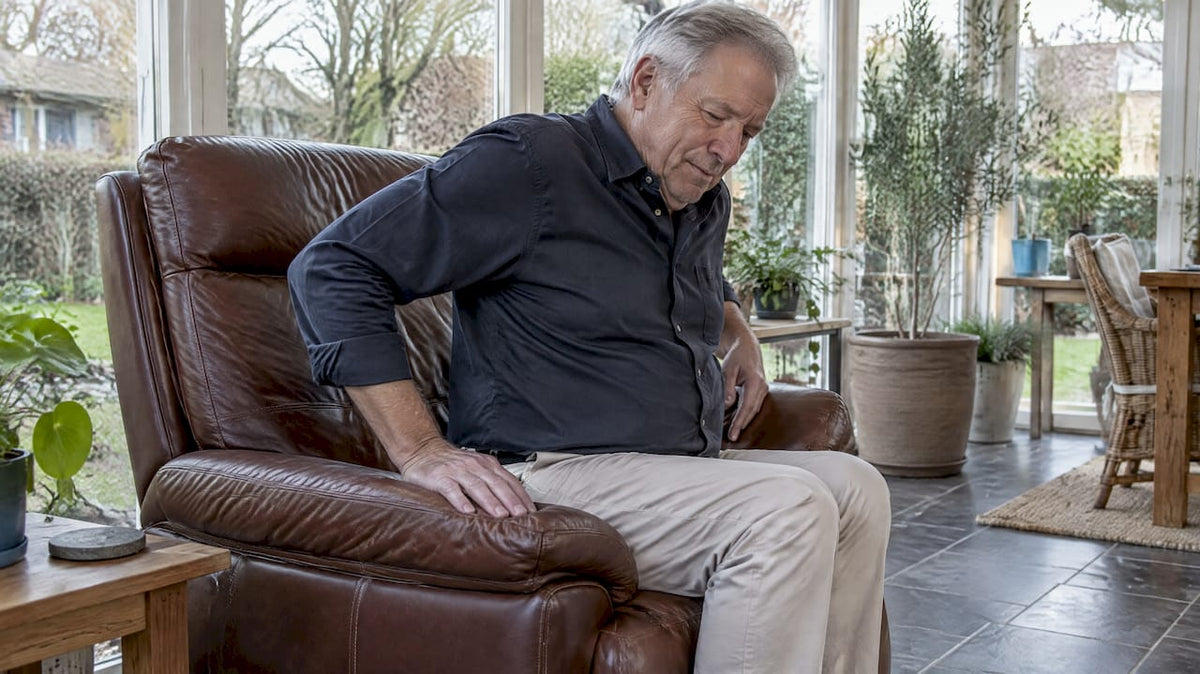 Oudere man verplaatst zich in leren stoel
