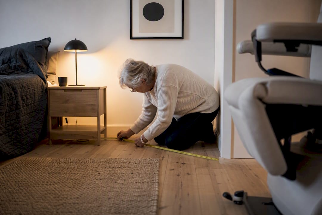 Oudere persoon meet ruimte voor stoel thuis
