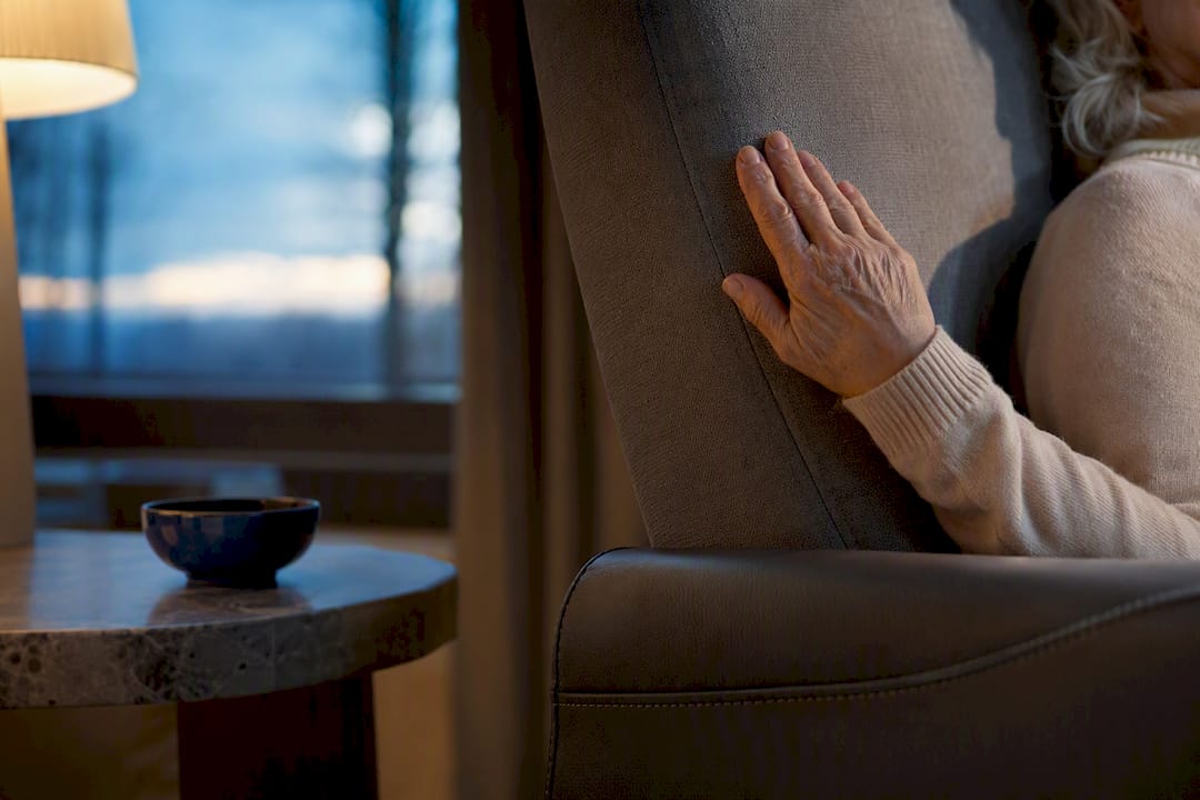 Hand op een verwarmde rugleuning in de woonkamer