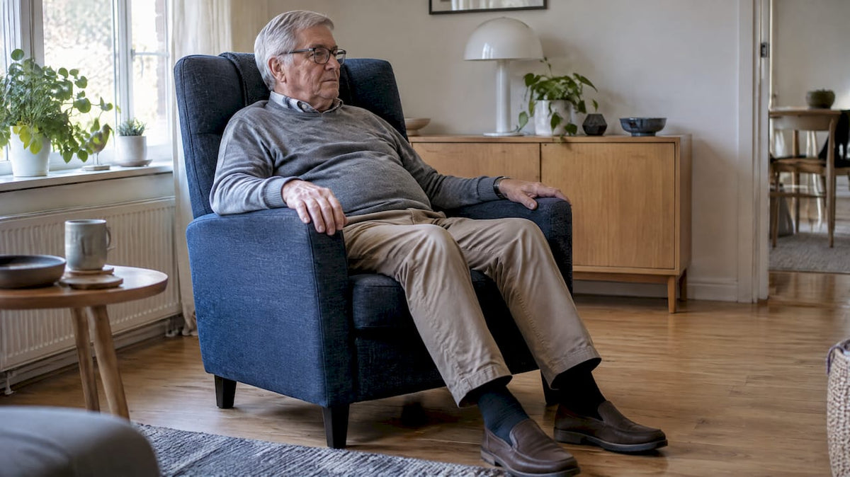Oudere man zit comfortabel achterin een fauteuil